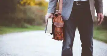 man holding book on road during daytime