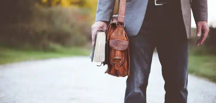 man holding book on road during daytime